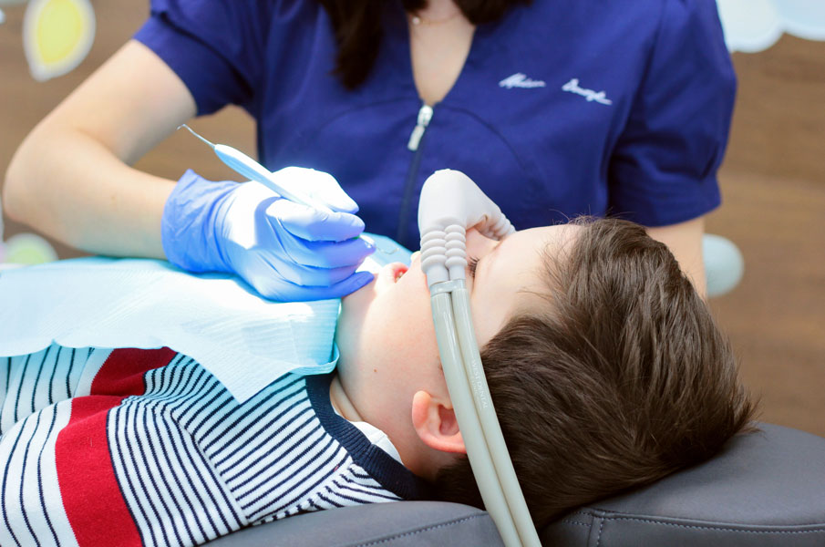 Детский стоматолог лечит зубы ребенку
